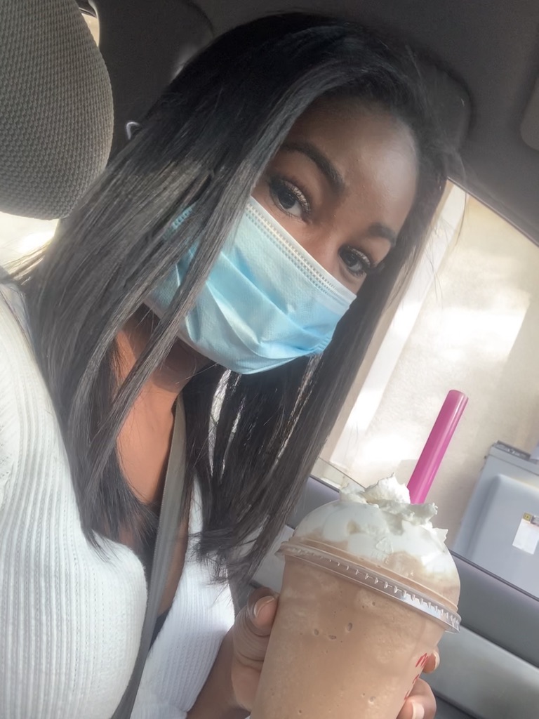 Girl in mask holding iced coffee