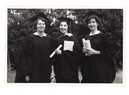 3 women in black commencement regalia, holding diplomas