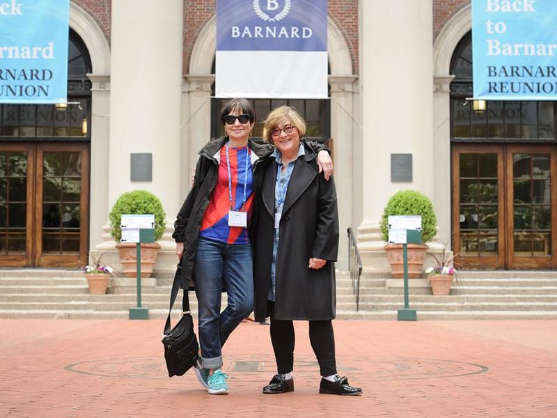 2 women, one arm around the other's shoulders, on Barnard's campus