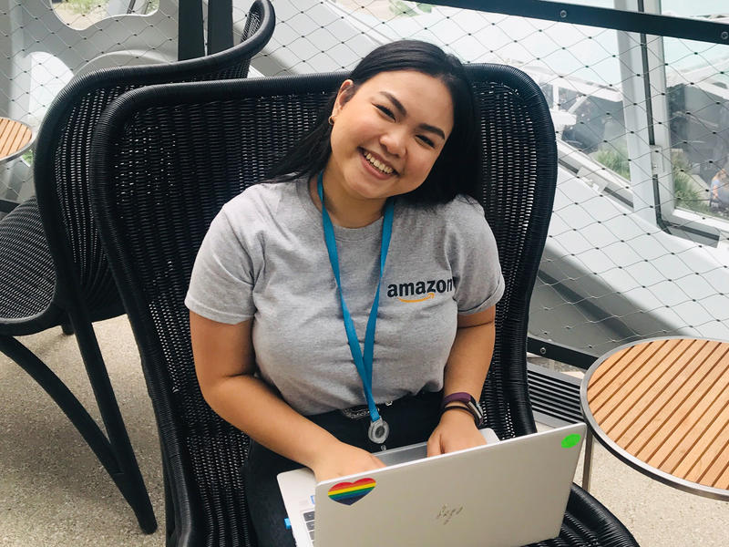Kim Samala wearing an Amazon t-shirt, working on a laptop