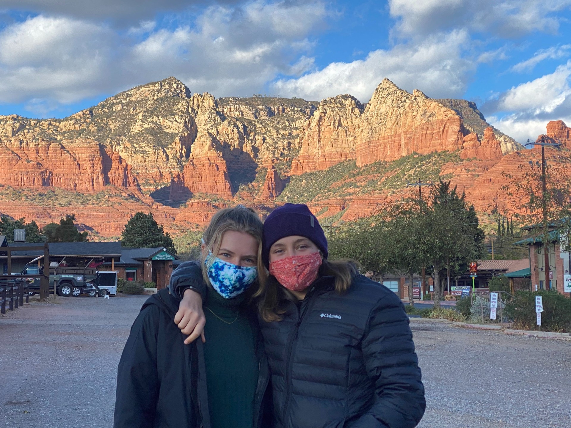Two students with red rocks lit up by sun behind 