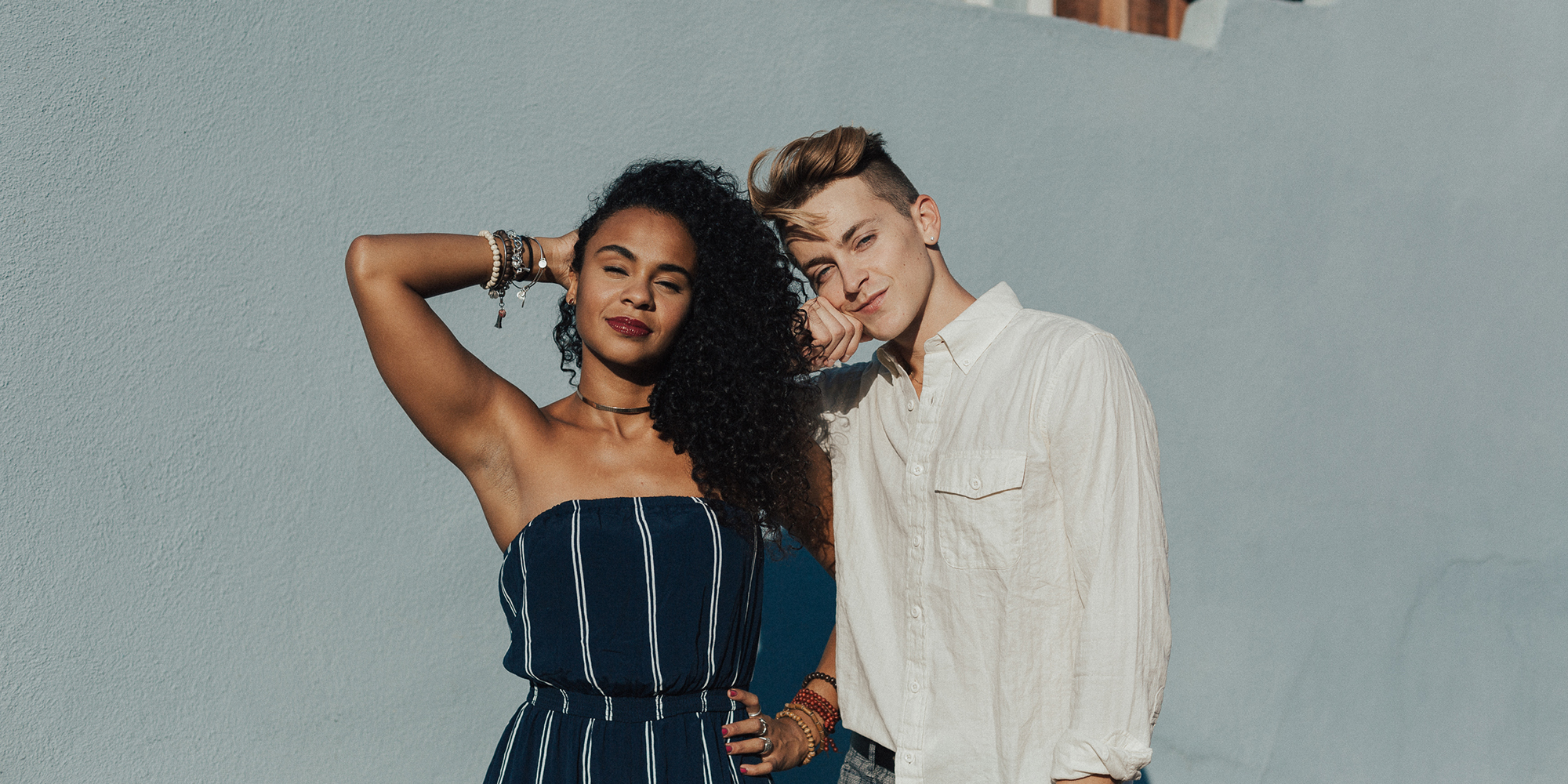 a man in white and woman in black stand close