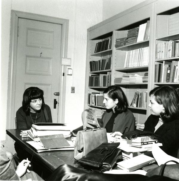 Three girls discuss during class
