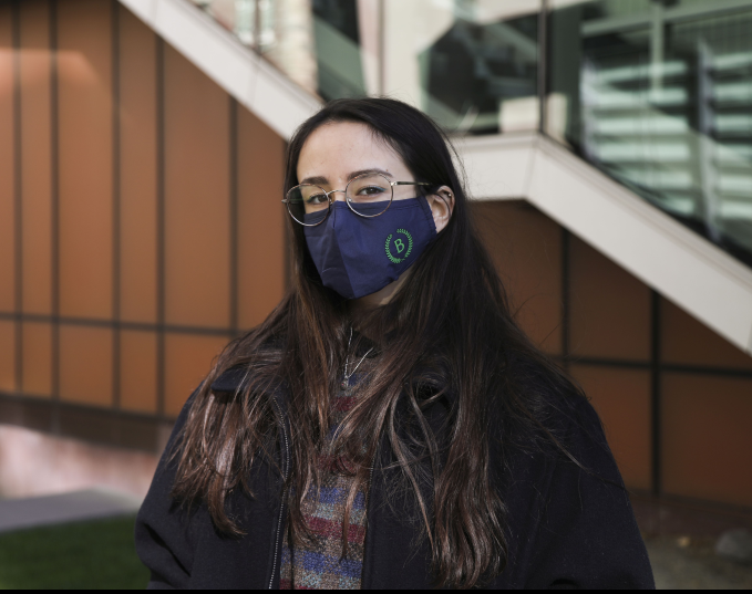 Student Tamia Lewis standing in front of the Diana Center with her navy blue Barnard Health Ambassador mask on.