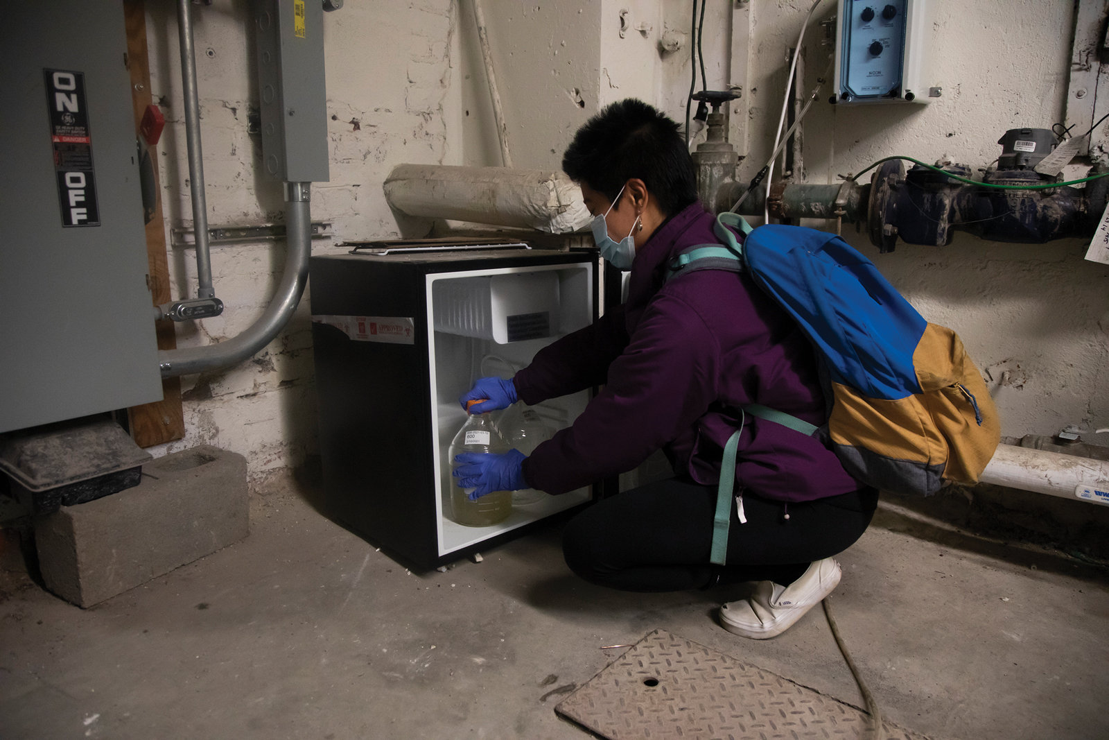 Janet Vo ’22 removes a sample bottle from the refrigerator to bring for analysis and adds a new sterile bottle to prepare for the next sample.