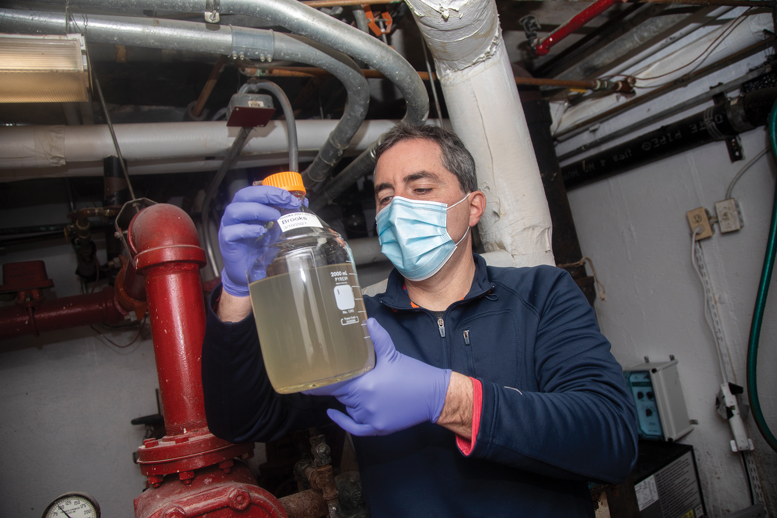 Professor Brian Mailloux examines a sample of wastewater that was just collected.