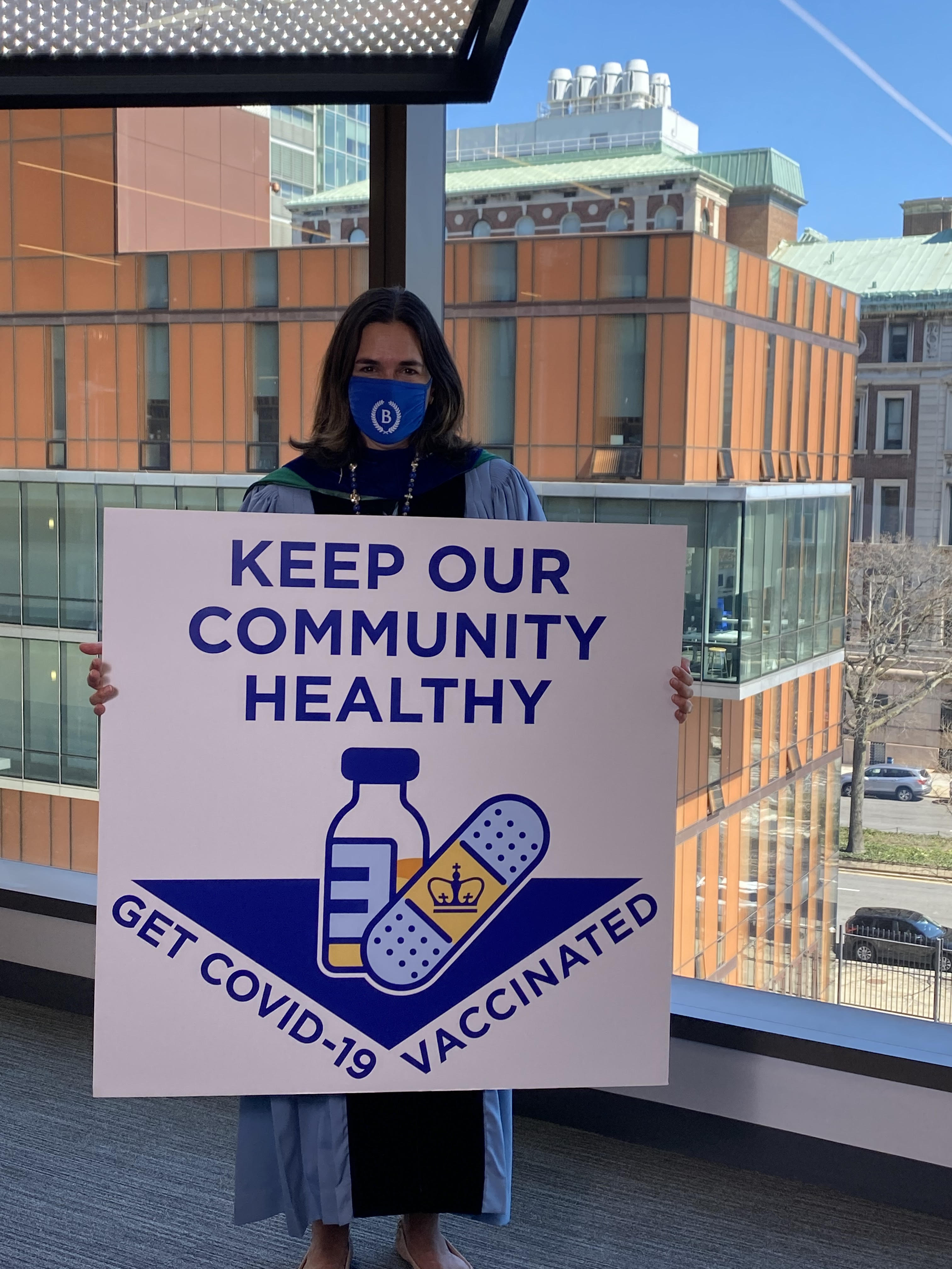 President Beilock holding a sign that says "Keep Our Community Safe. Get COVID-19 Vaccinated."
