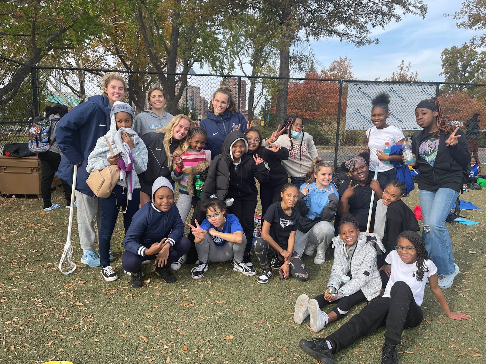 Corrigan (center), members of the Columbia lacrosse team, the Harlem-based middle school girl's lacrosse team.
