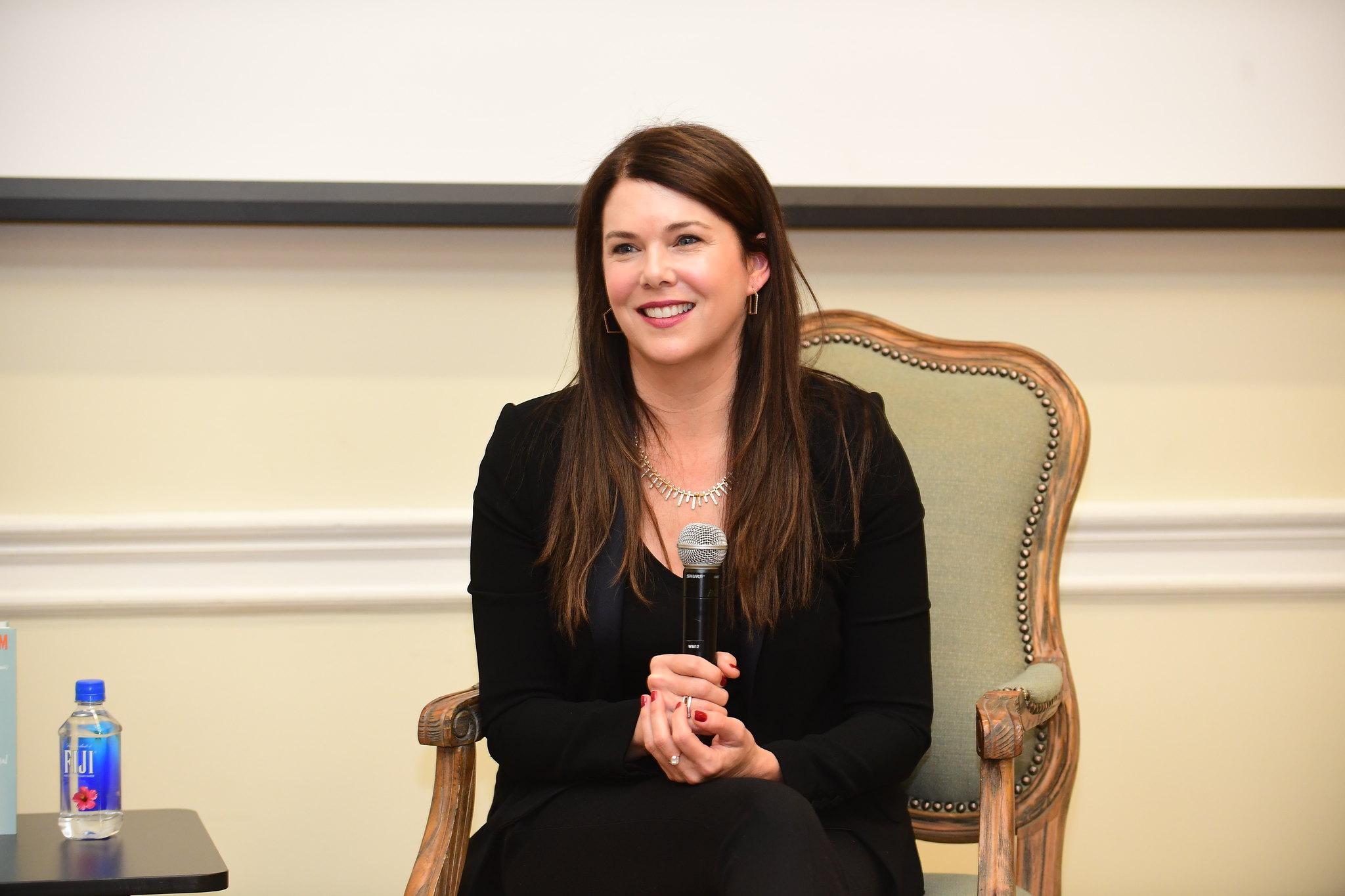 Lauren Graham sitting in a chair holding a microphone in the Barnard James Room