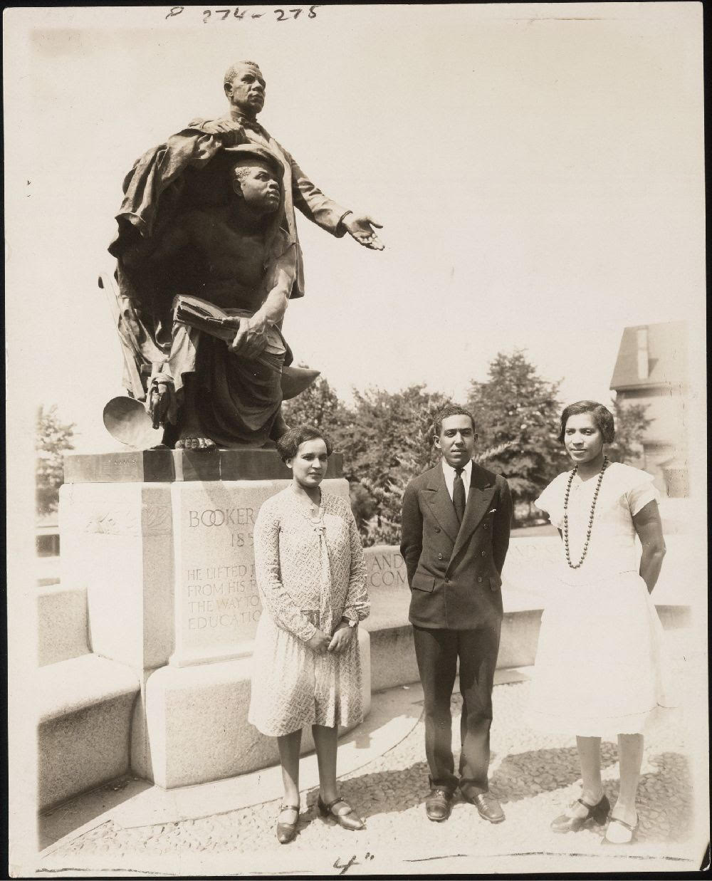 Archival Image of Langston Hughes and Zore Neale Hurston standing in front of a Booker T Washington memorial. Image taken from the Langston Hughes Papers in the James Weldon Johnson Collection  