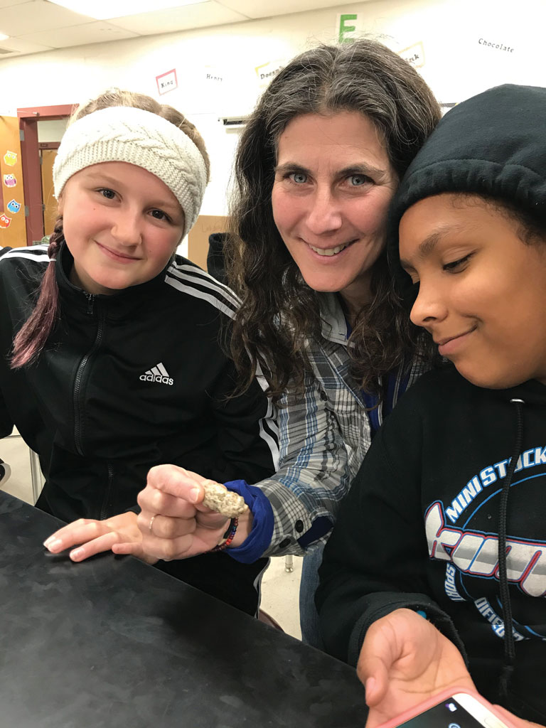 Susie Spikol ’90 observing an owl pellet with participants of Lab Girls 