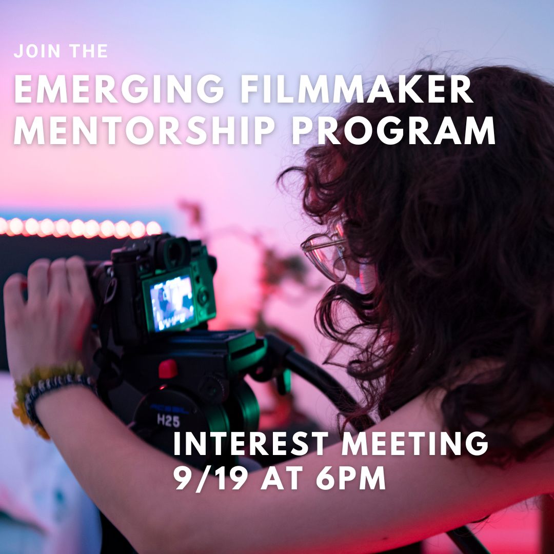 picture of young woman with curly hair operating a camera