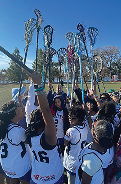 Harlem Lacrosse team in a huddle on the field