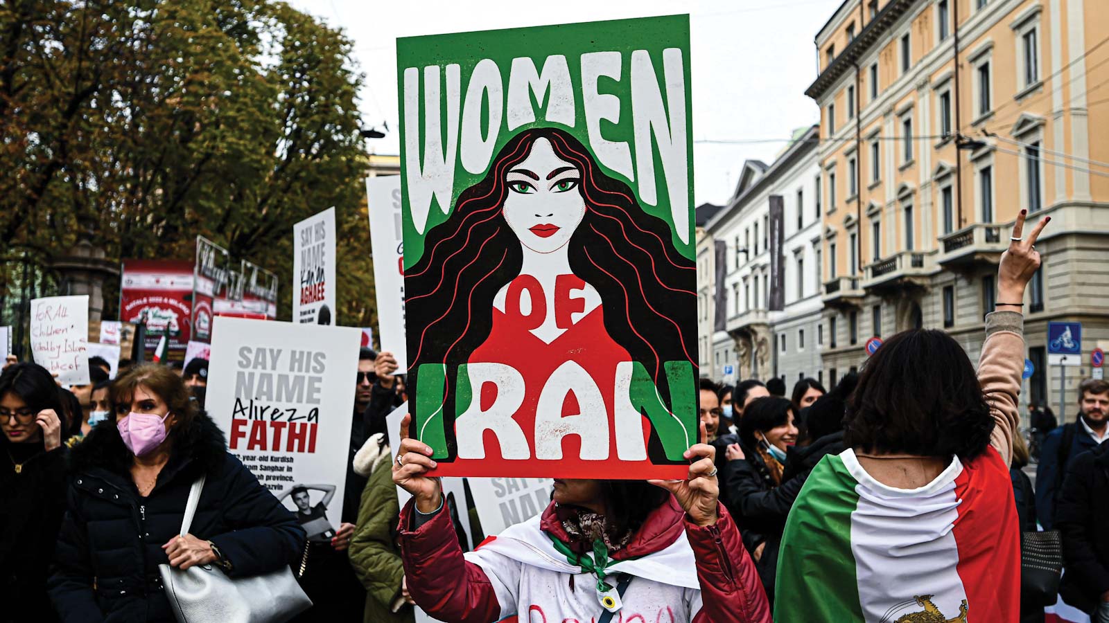 Women protesting holding a poster that reads "women of Iran"