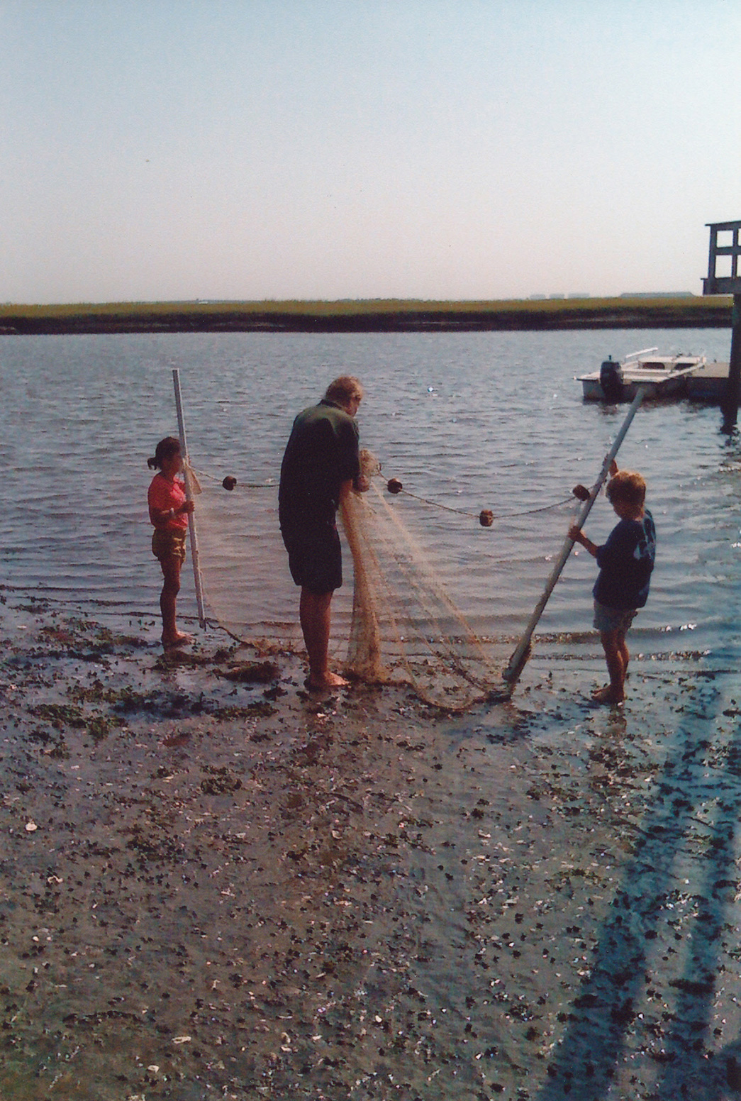An adult and two children with net on beach