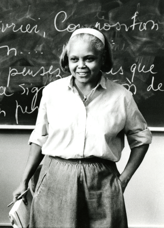 Black and white image of Professor Prettyman with chalkboard backdrop