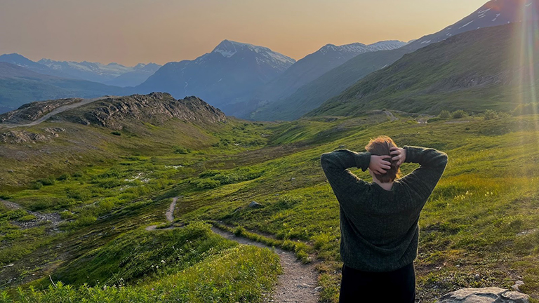 photo of Zoe Foshee (back to the camera, looking at mountains)