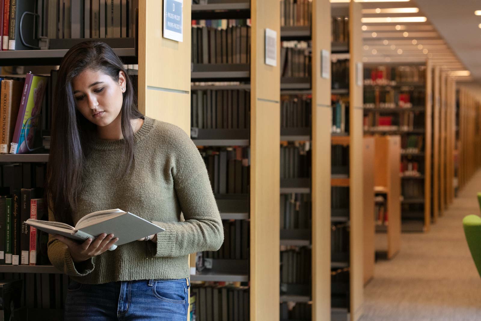 Student reading a book in the library