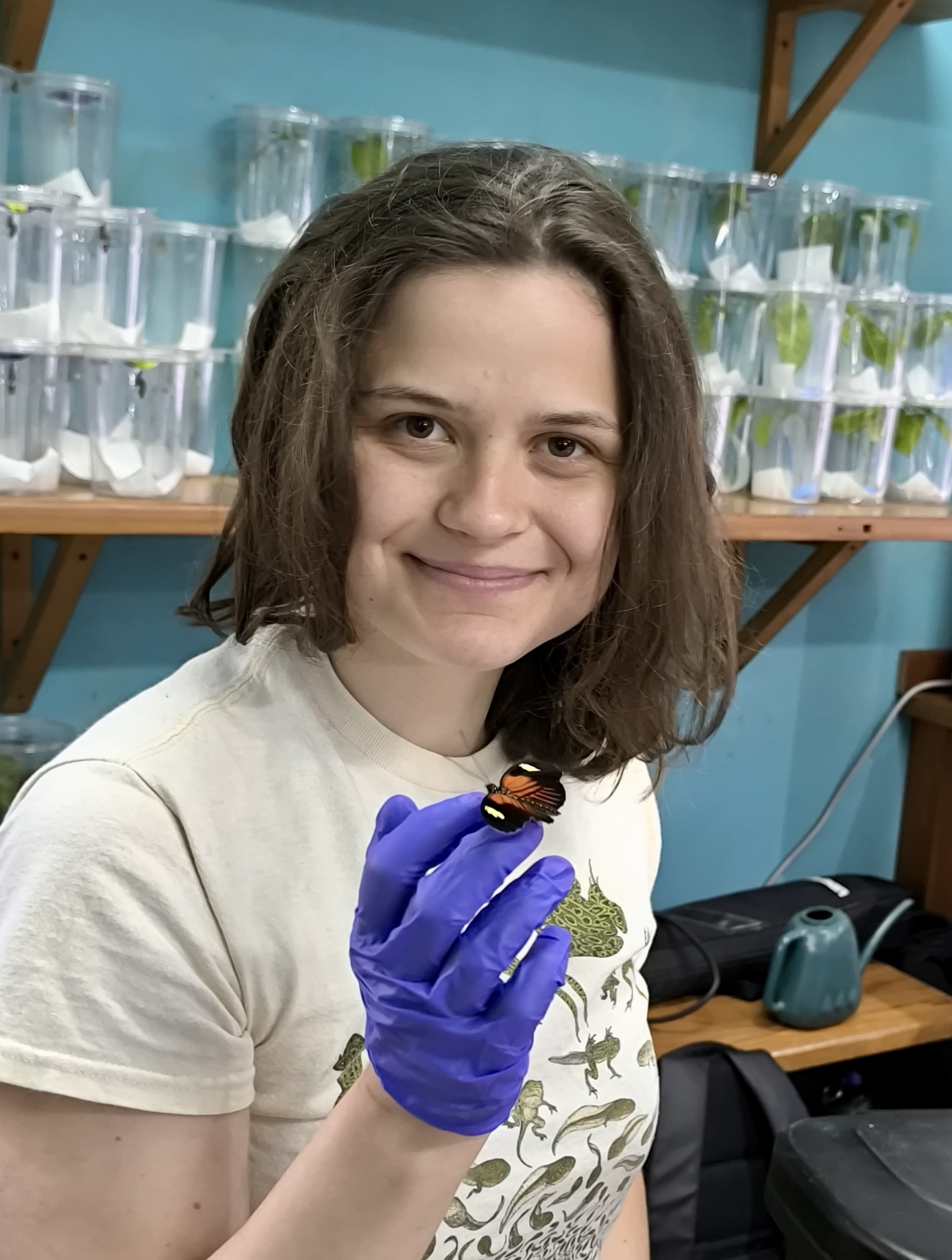 Laura holds a heliconius melpomene butterfly.