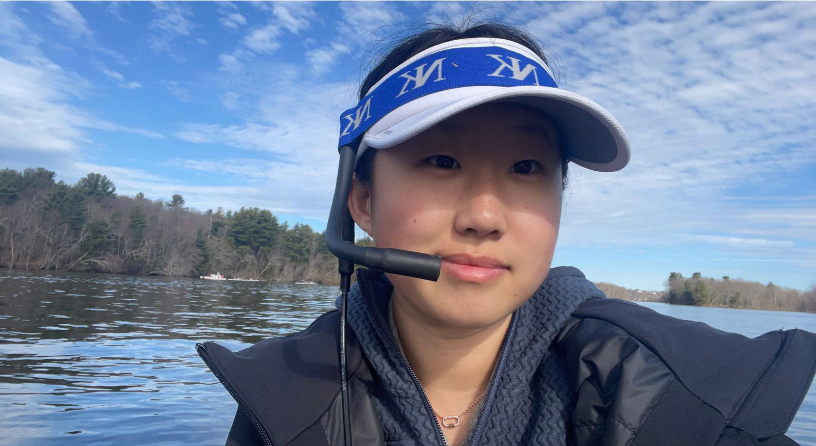 young woman leading crew on the water with a microphone and visor