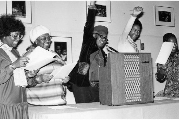 Five women standing behind a podium