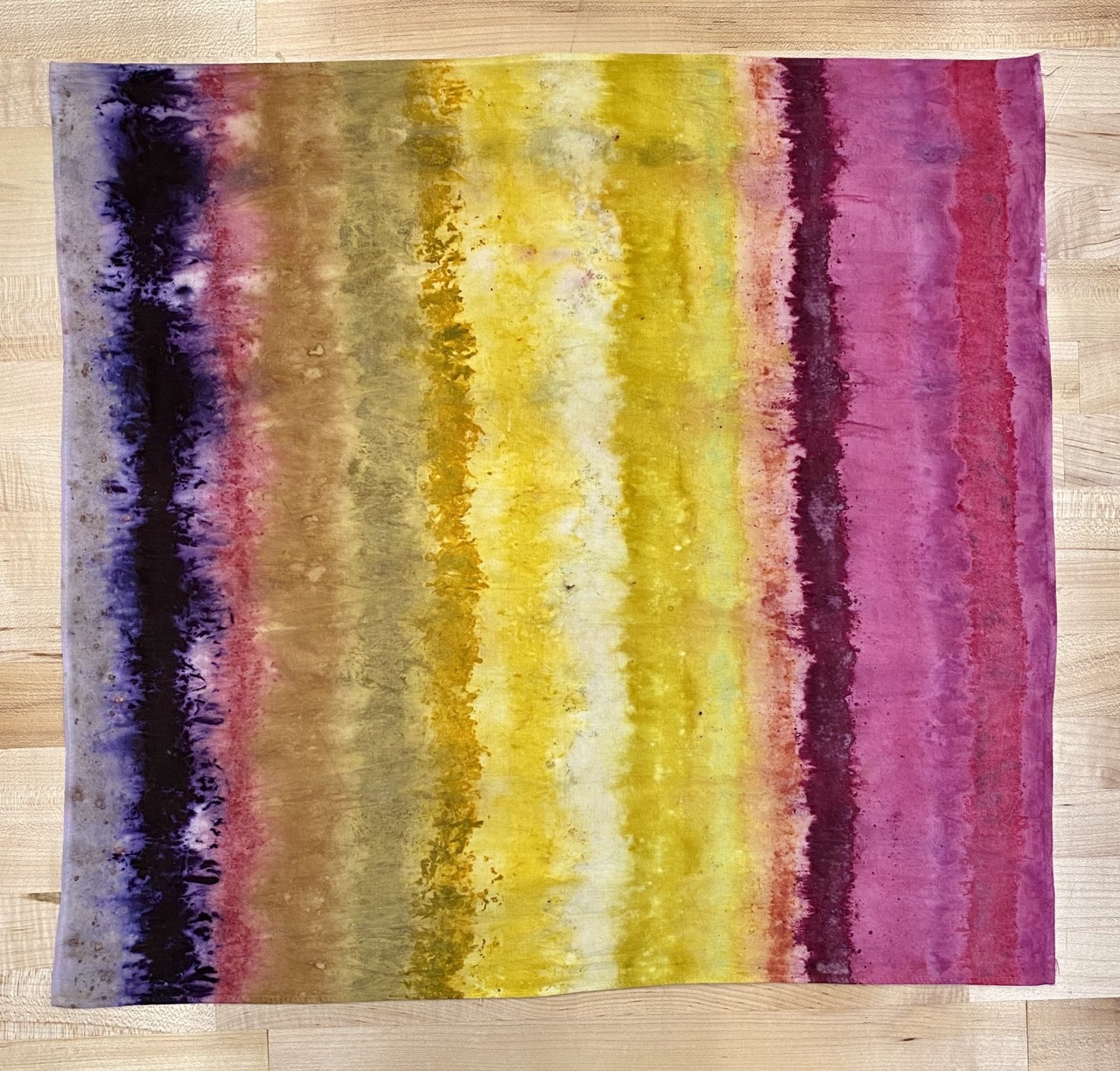 a rainbow vertical striped naturally dyed bandana with purple, pink, yellow stripes