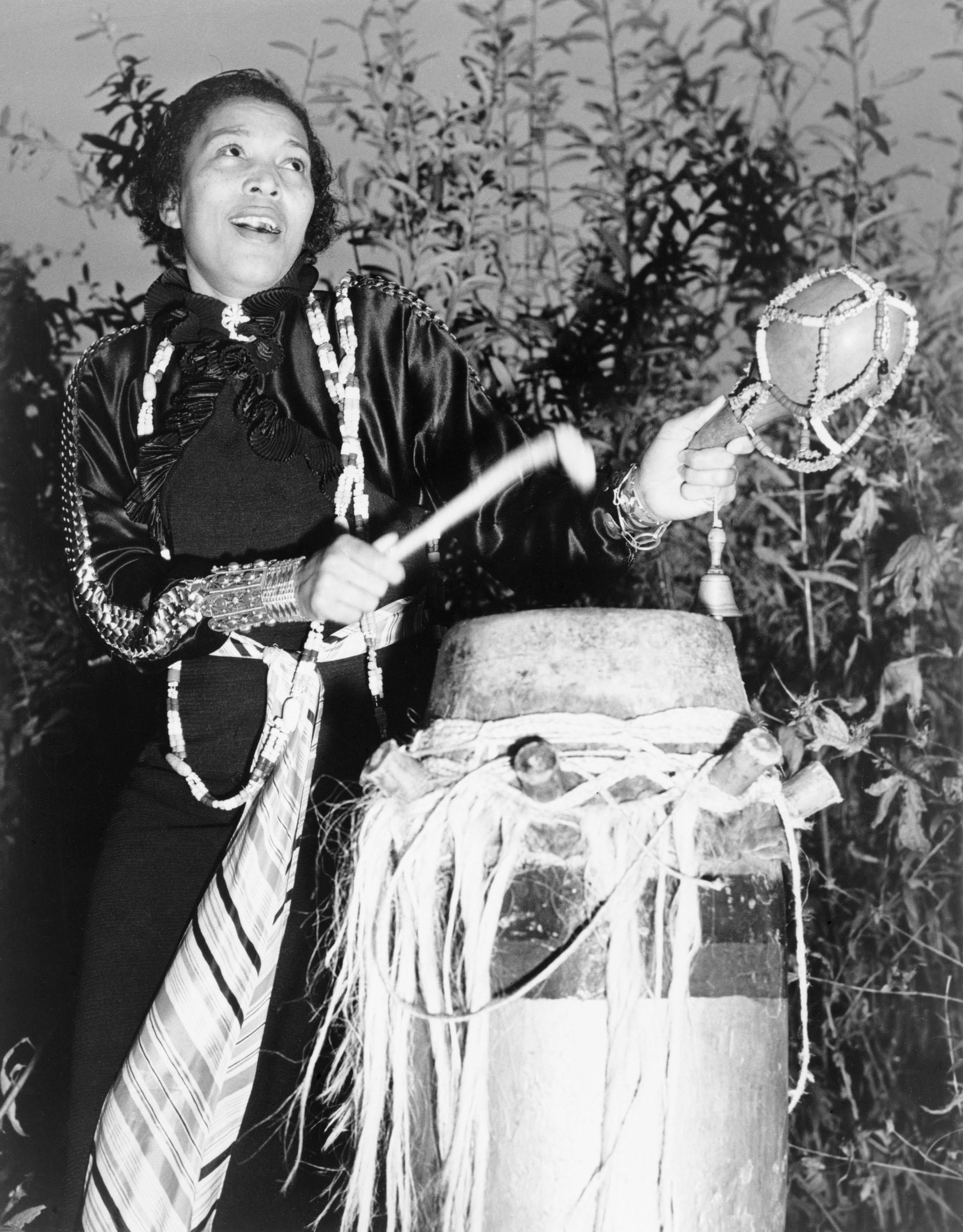 Black and white photo with woman beating a drum