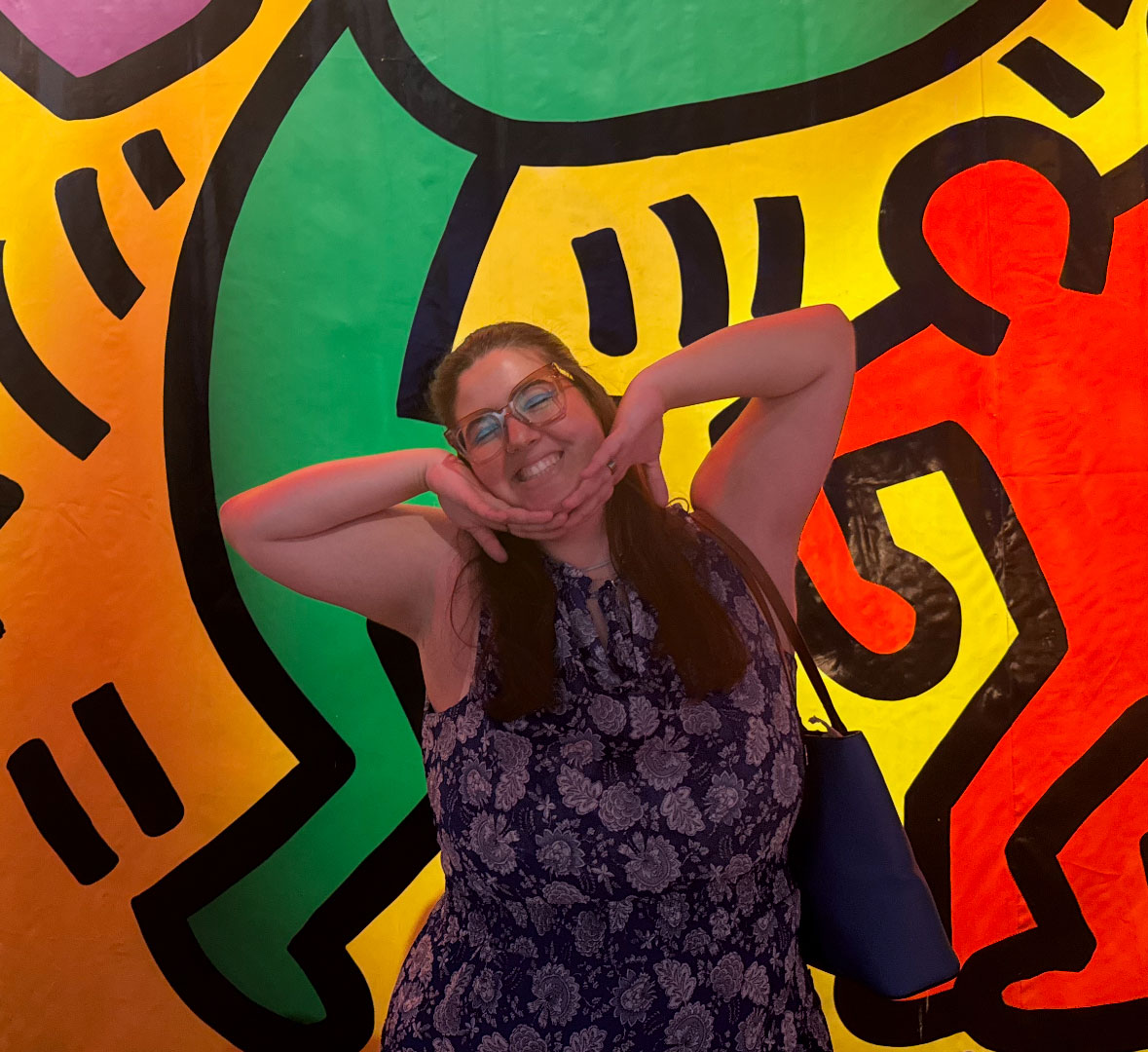 Young woman pose in front of Keith Haring art
