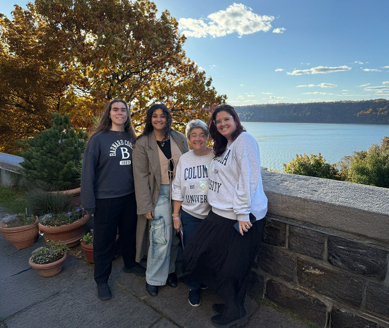 Four women of different generations pose in front of river and trees