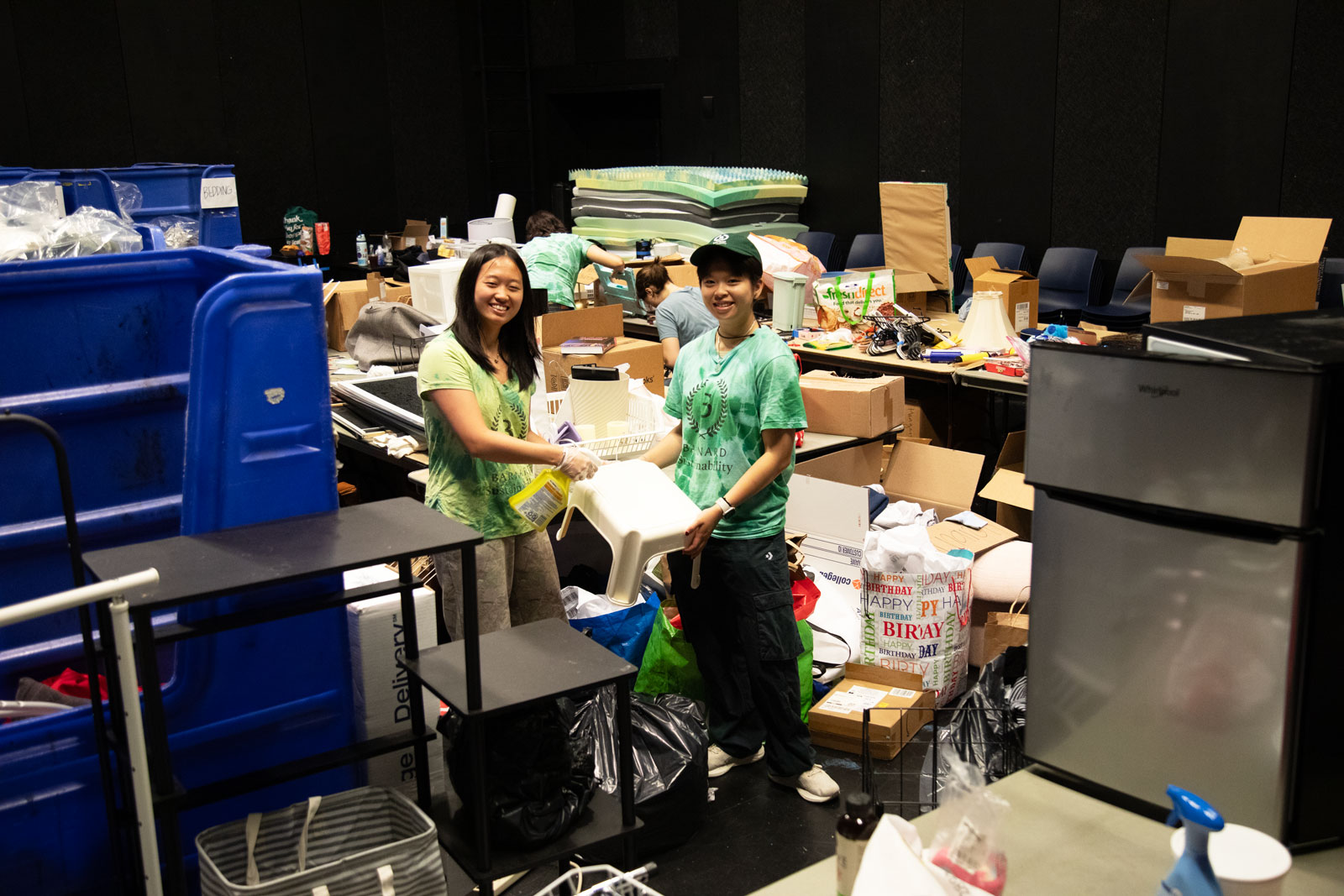 Two students standing in room of stuff