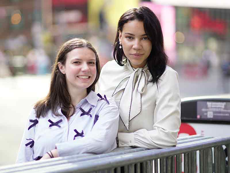 Two women pose side by side