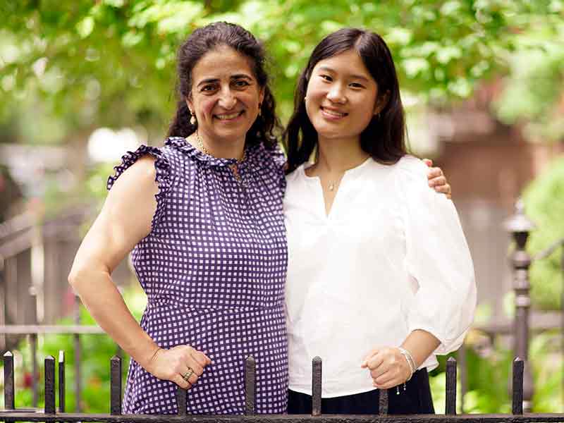 Two women pose side by side