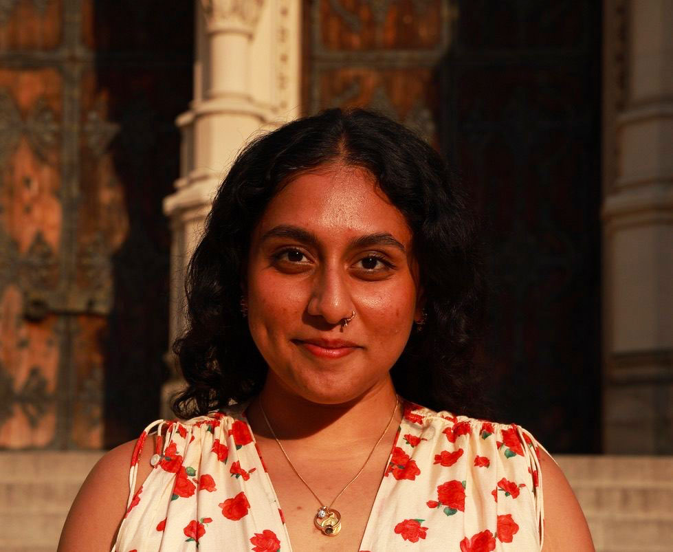 Woman with dark hair wearing red and white top