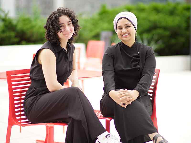 Two women sit side by side