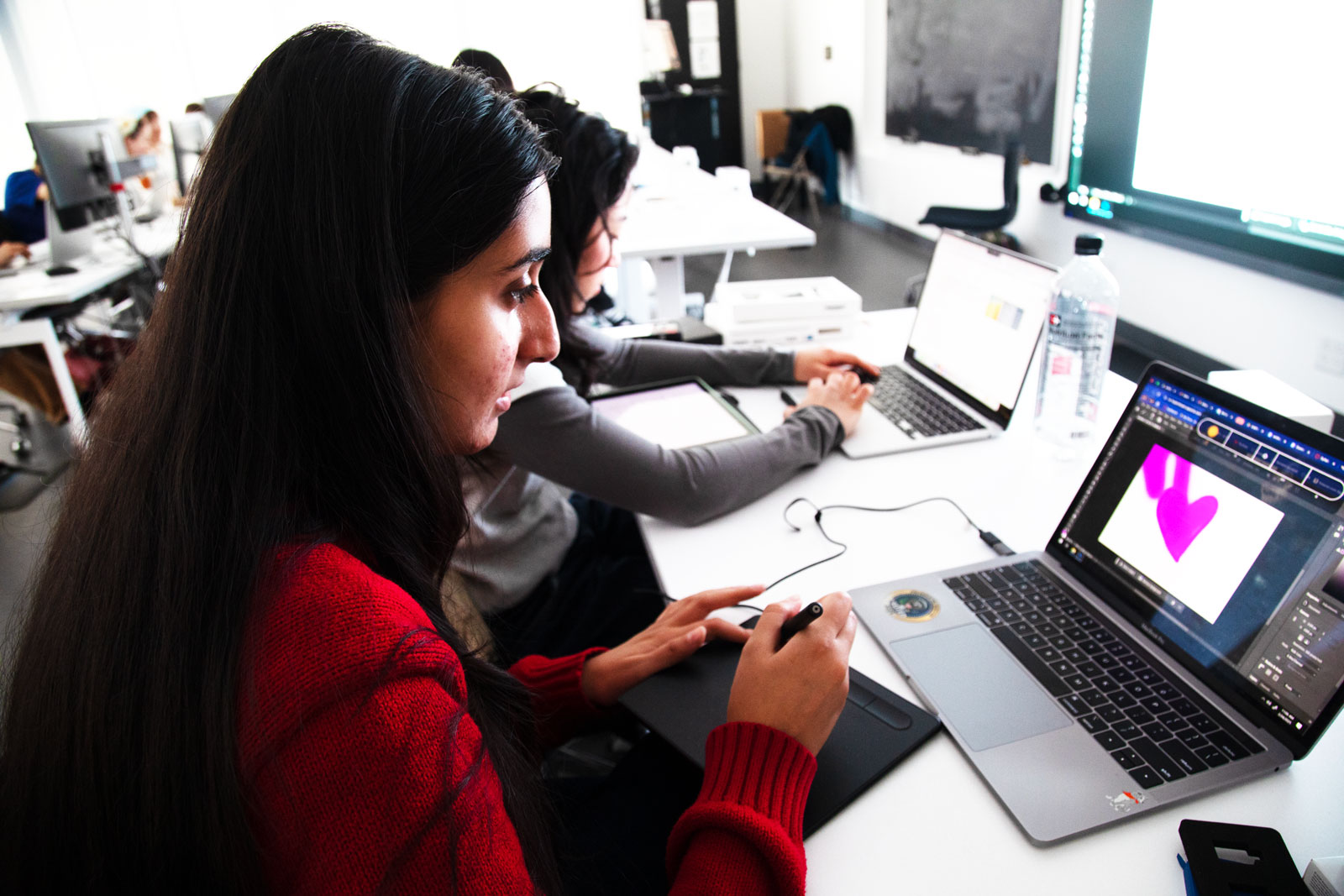 Woman sitting at computer screen with purple hearts drawn