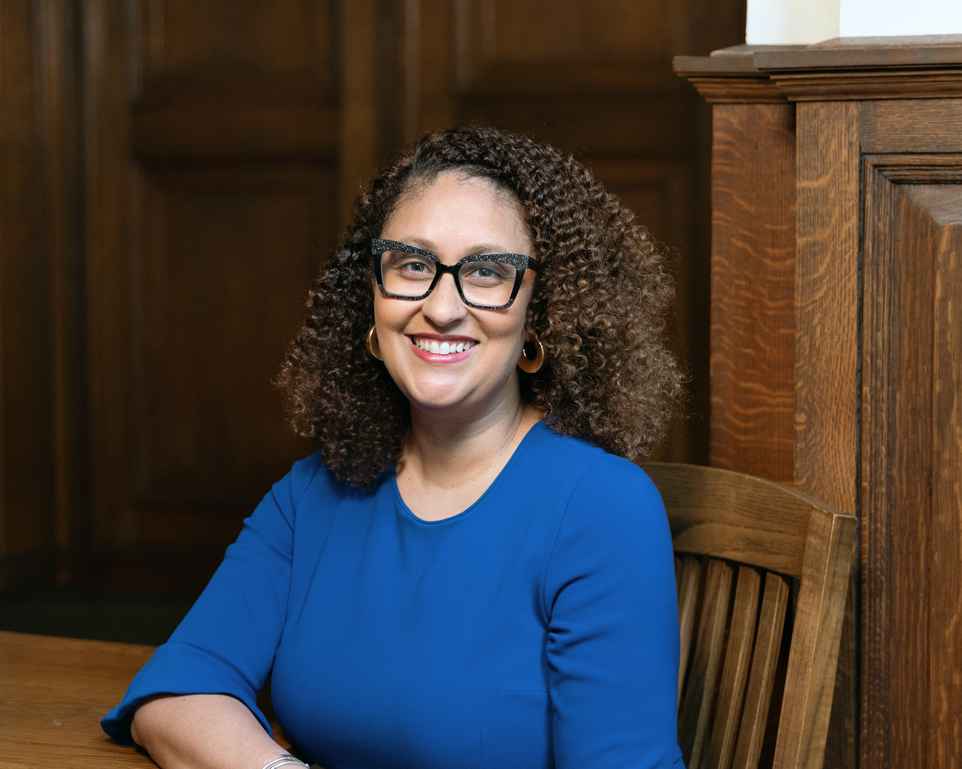 Photo of Kelli Murray sitting in a chair wearing a blue shirt