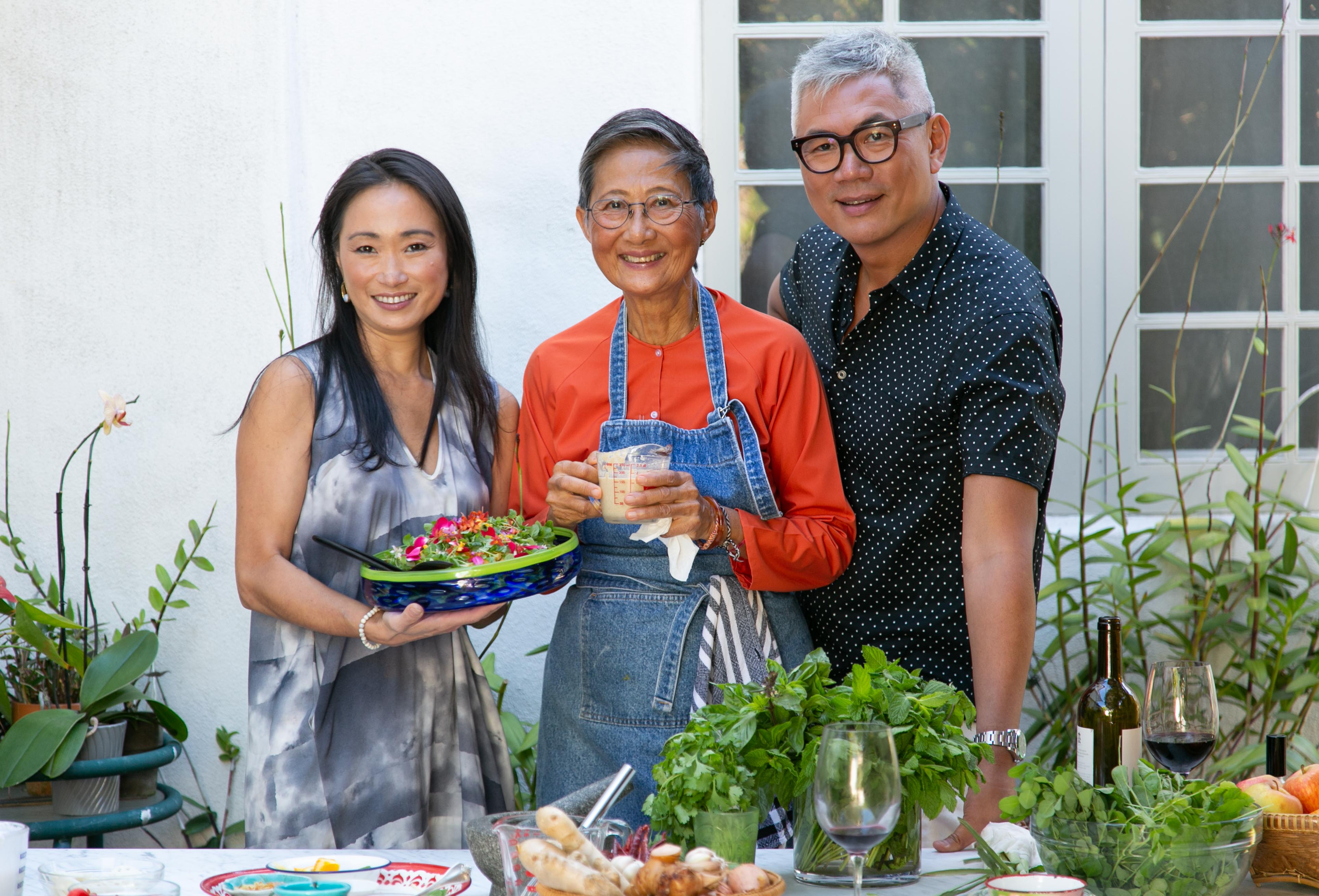 2 Asian women and one Asian man on the set of a cooking show