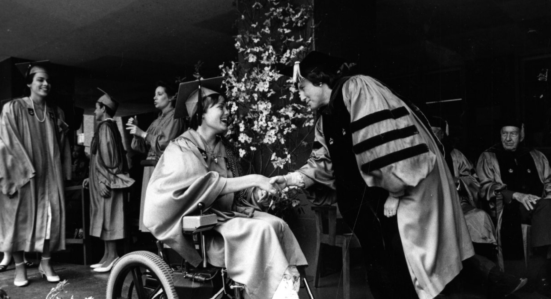 Barnard president Ellen Futter shakes hands with graduate in wheel chair