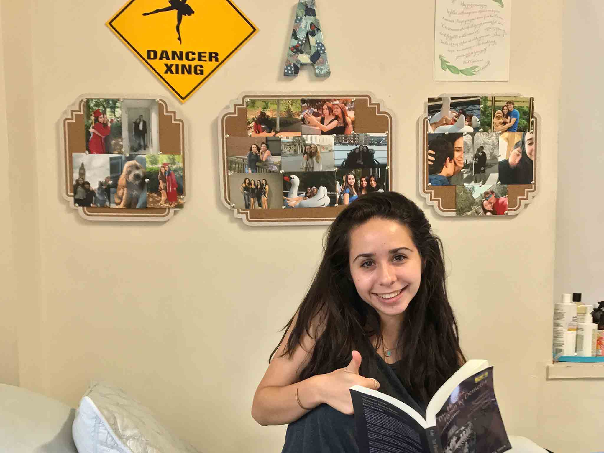 Young woman sitting on her bed holding a book