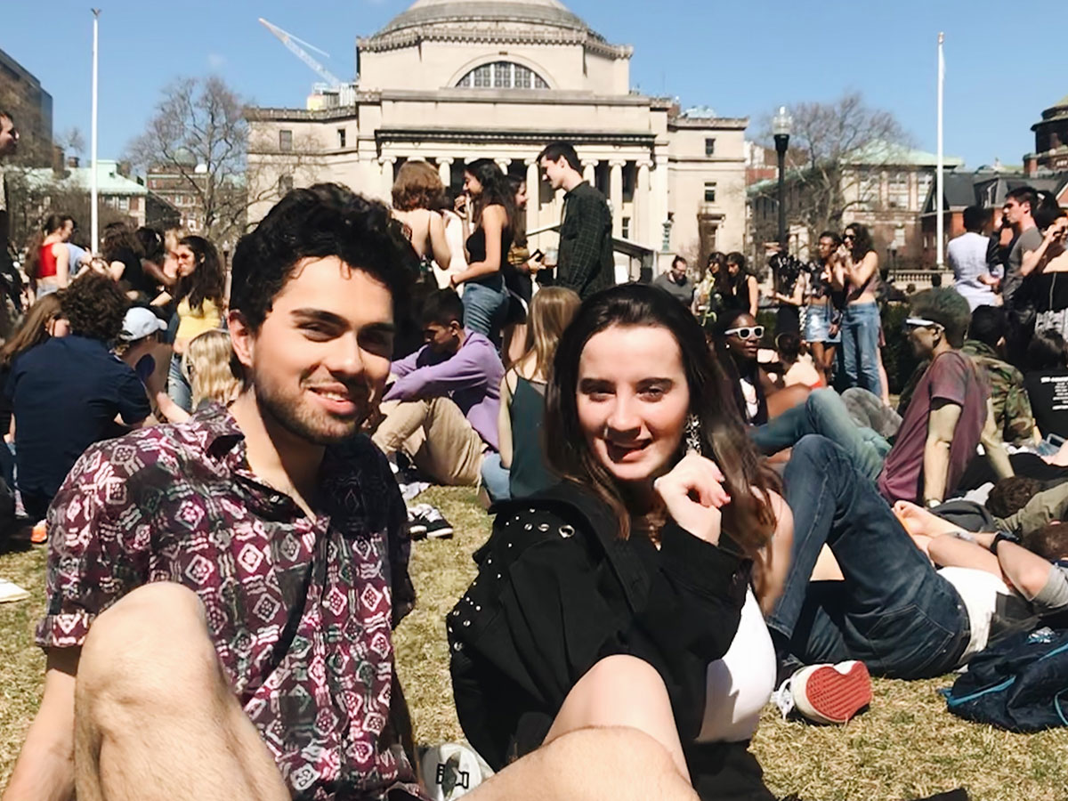 Young woman and young man sitting together on Columbia University lawn