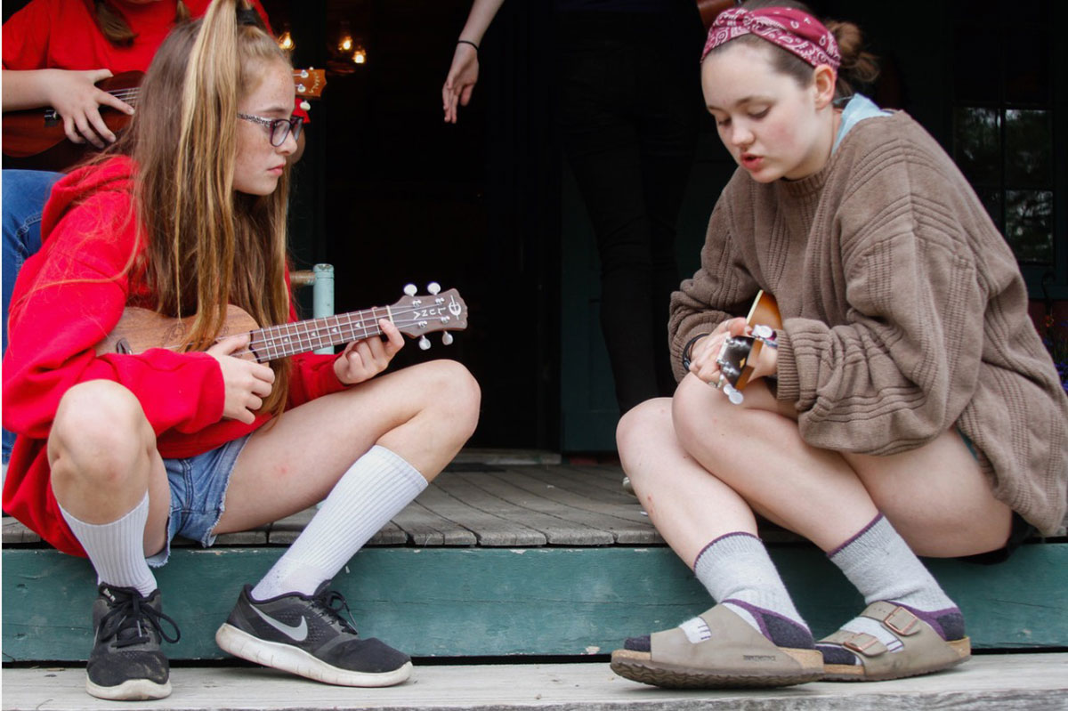 Ellie teaching student how to play the ukulele 