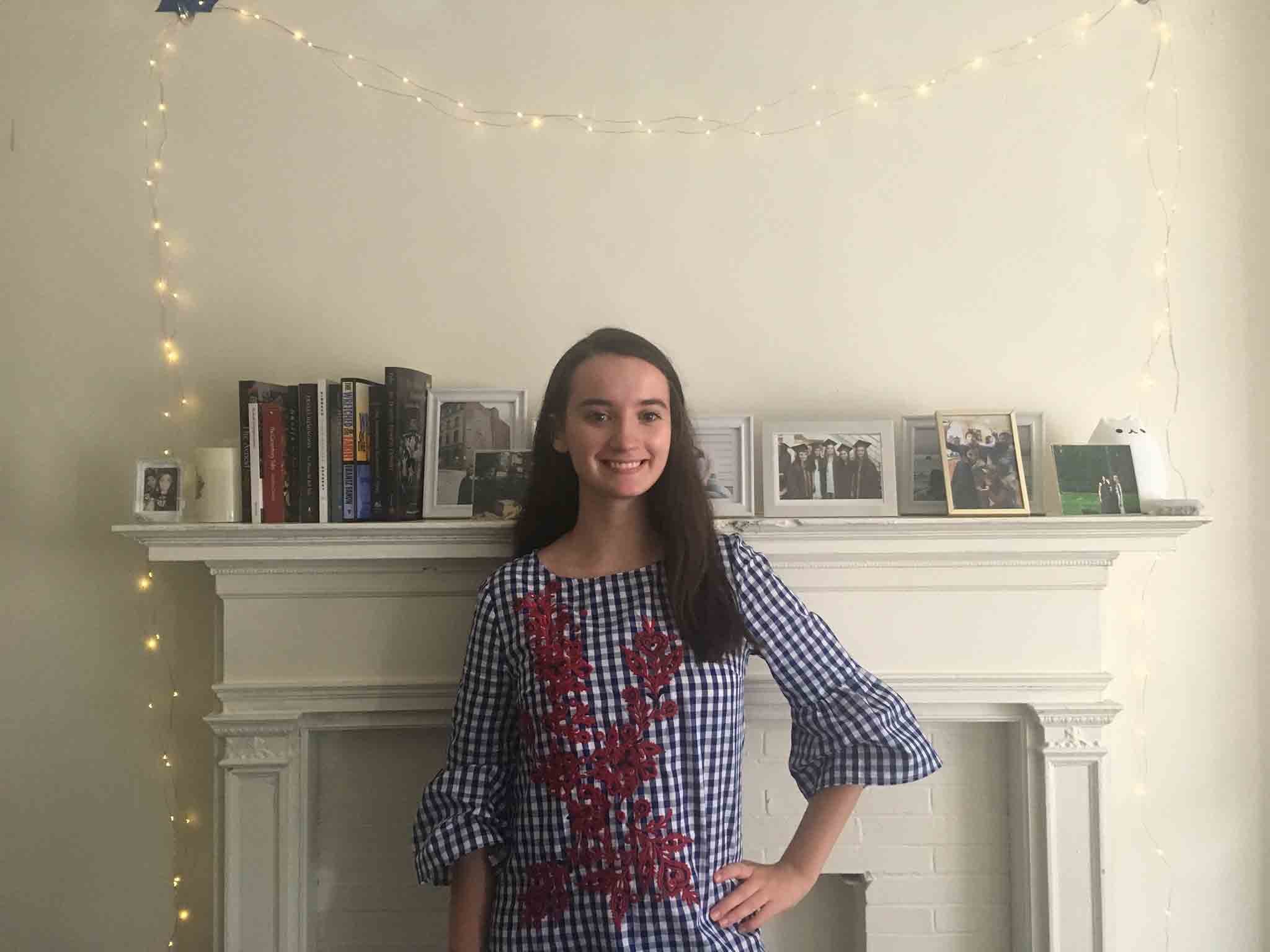 Young woman standing in front of fireplace