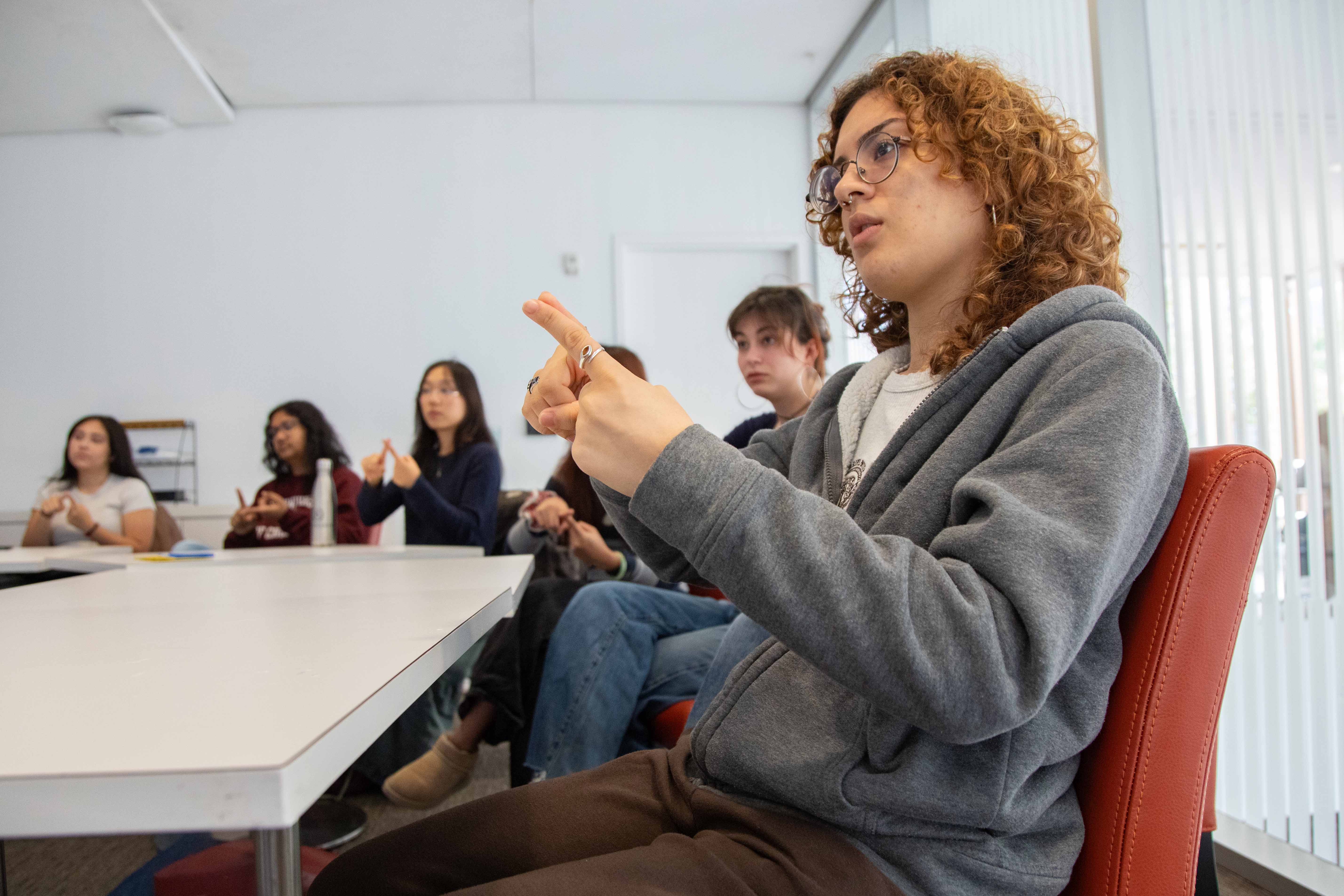 Students practicing ASL in classroom.