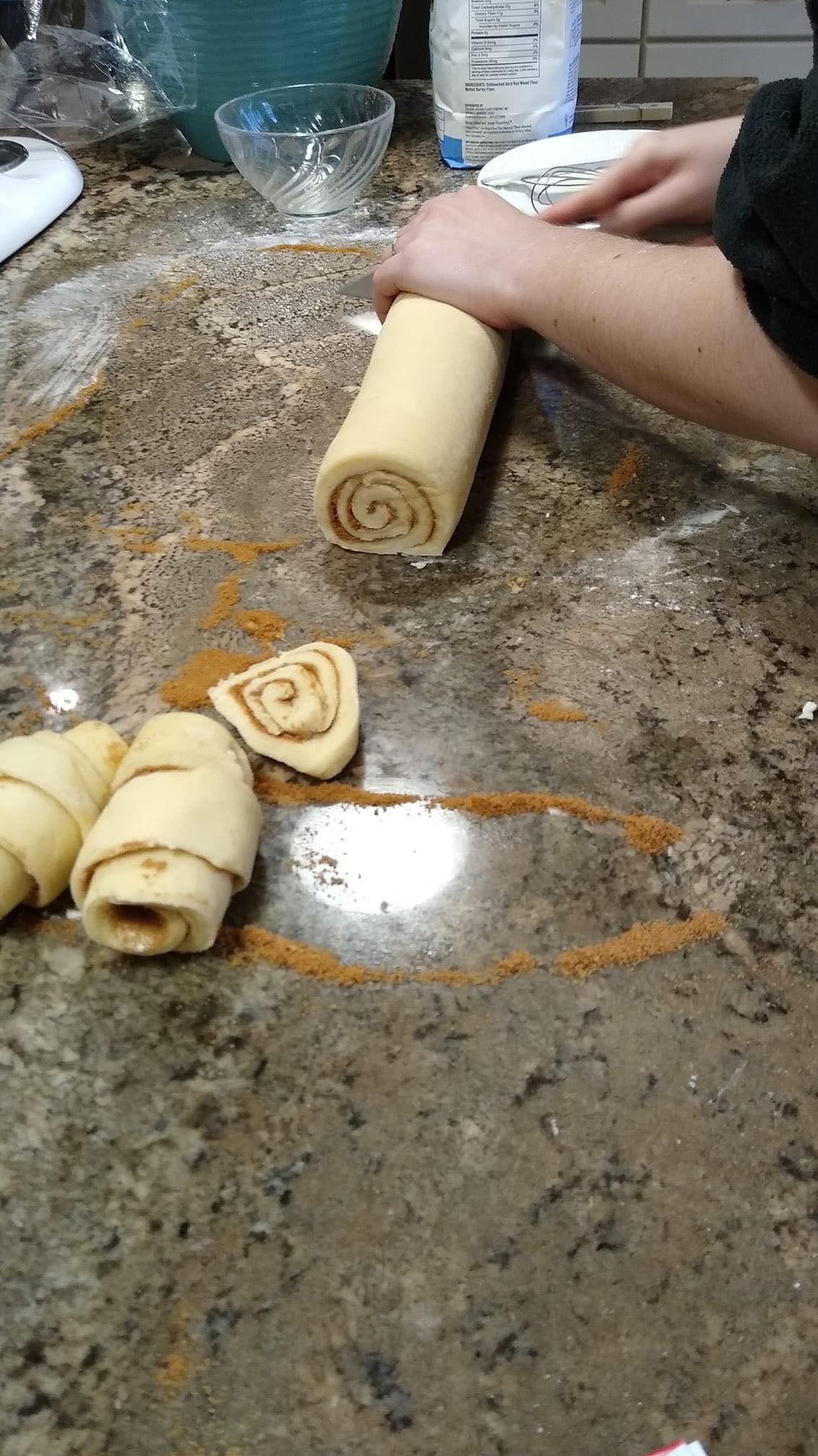 Emma Tabenken cutting cinnamon rolls to bake.