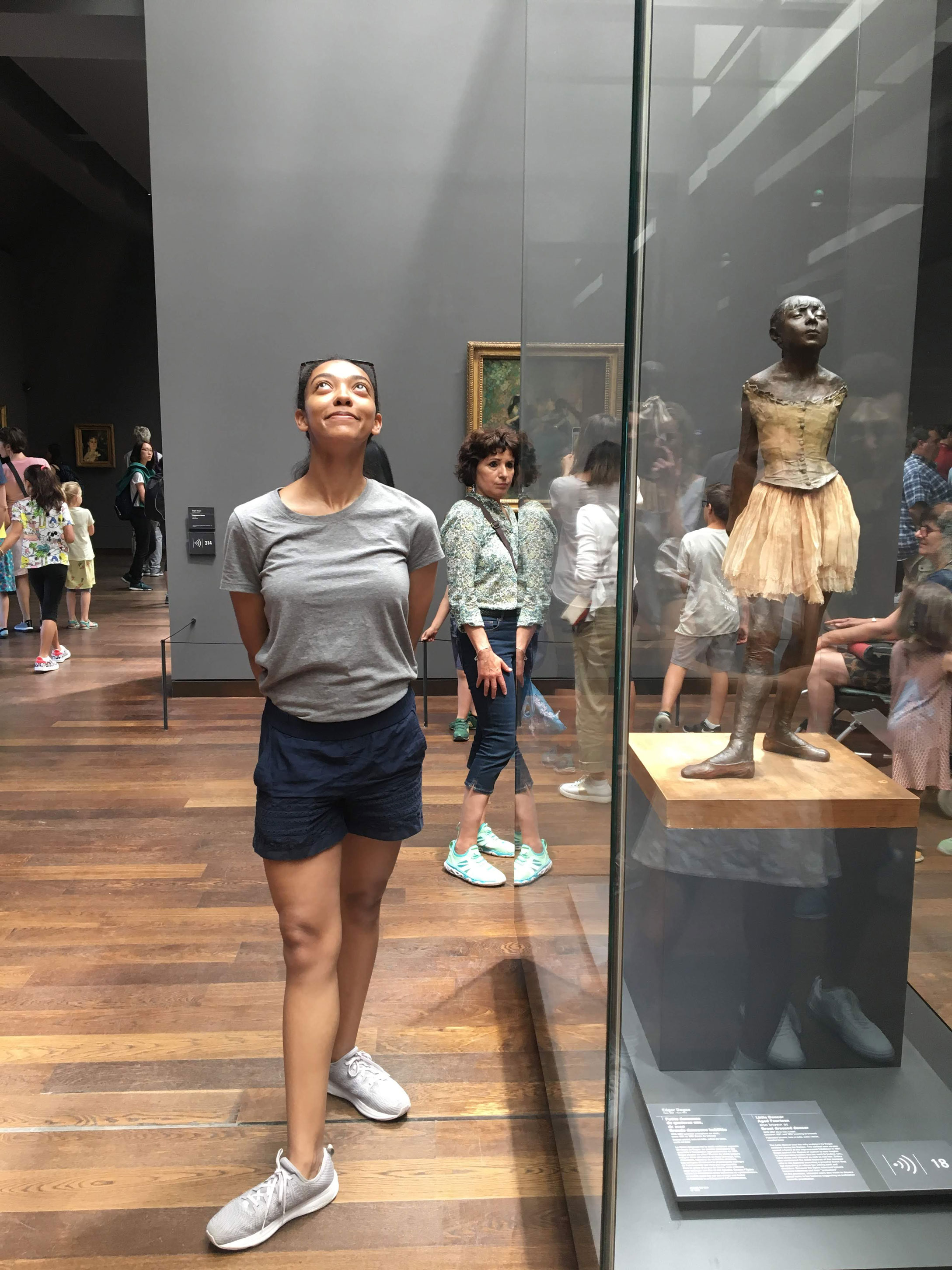 Young AFrican American woman posing next to Degas' The Dancer.