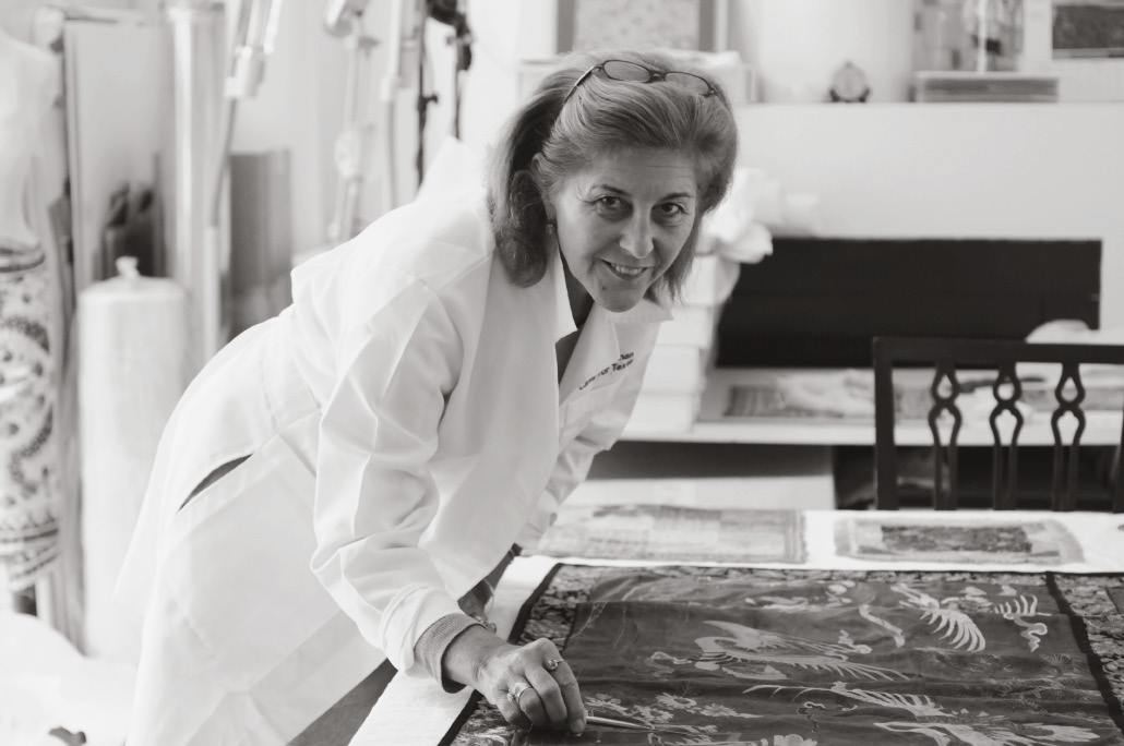 Woman posing in front of textiles