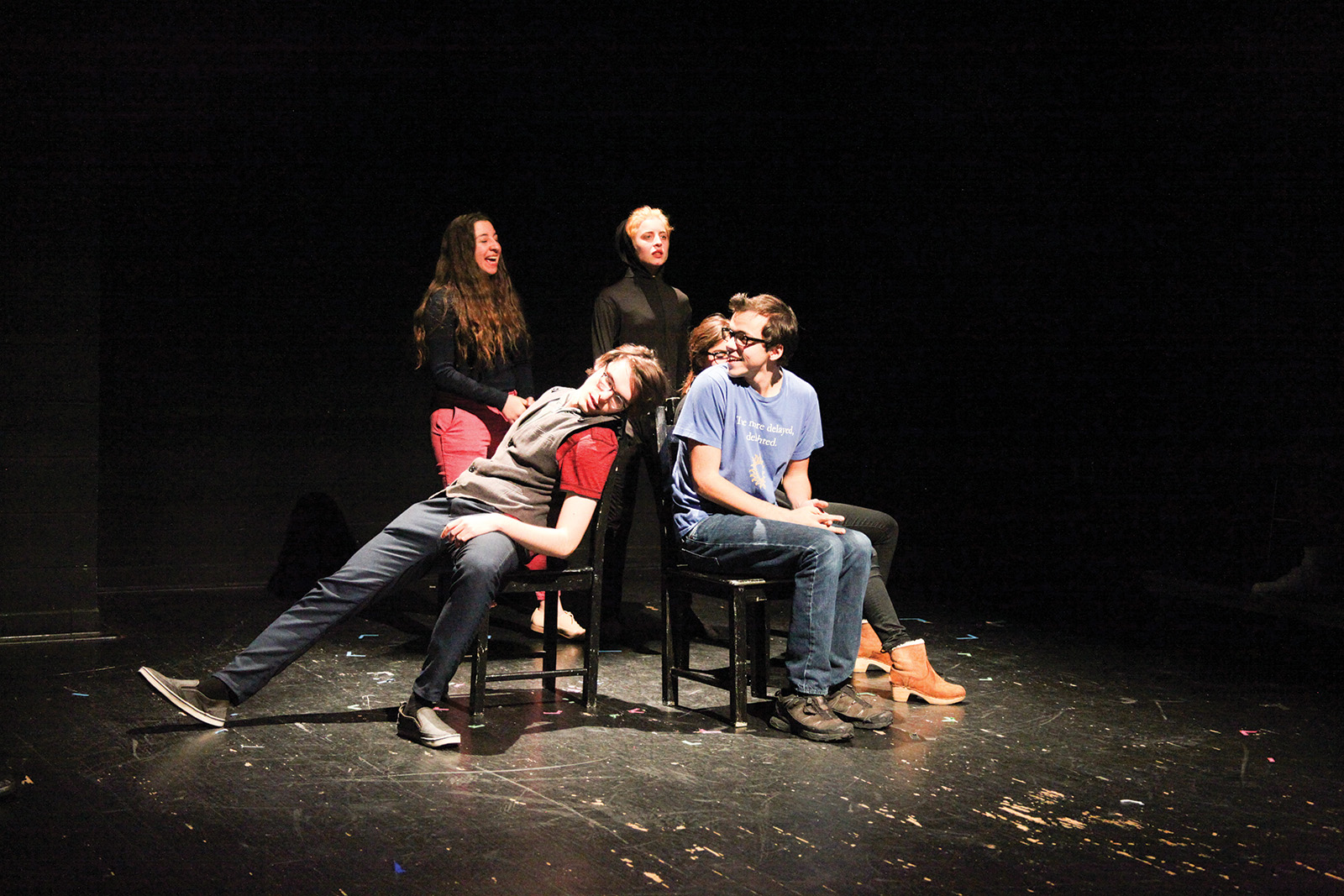 4 students on stage, 2 seated, 2 standing behind