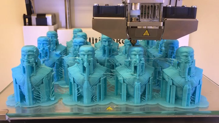 The chess pieces inside the 3-D printer. All the figures are cyan prior to being painted, because that's the color of the monofilament in the Design Center's 3D printing. 