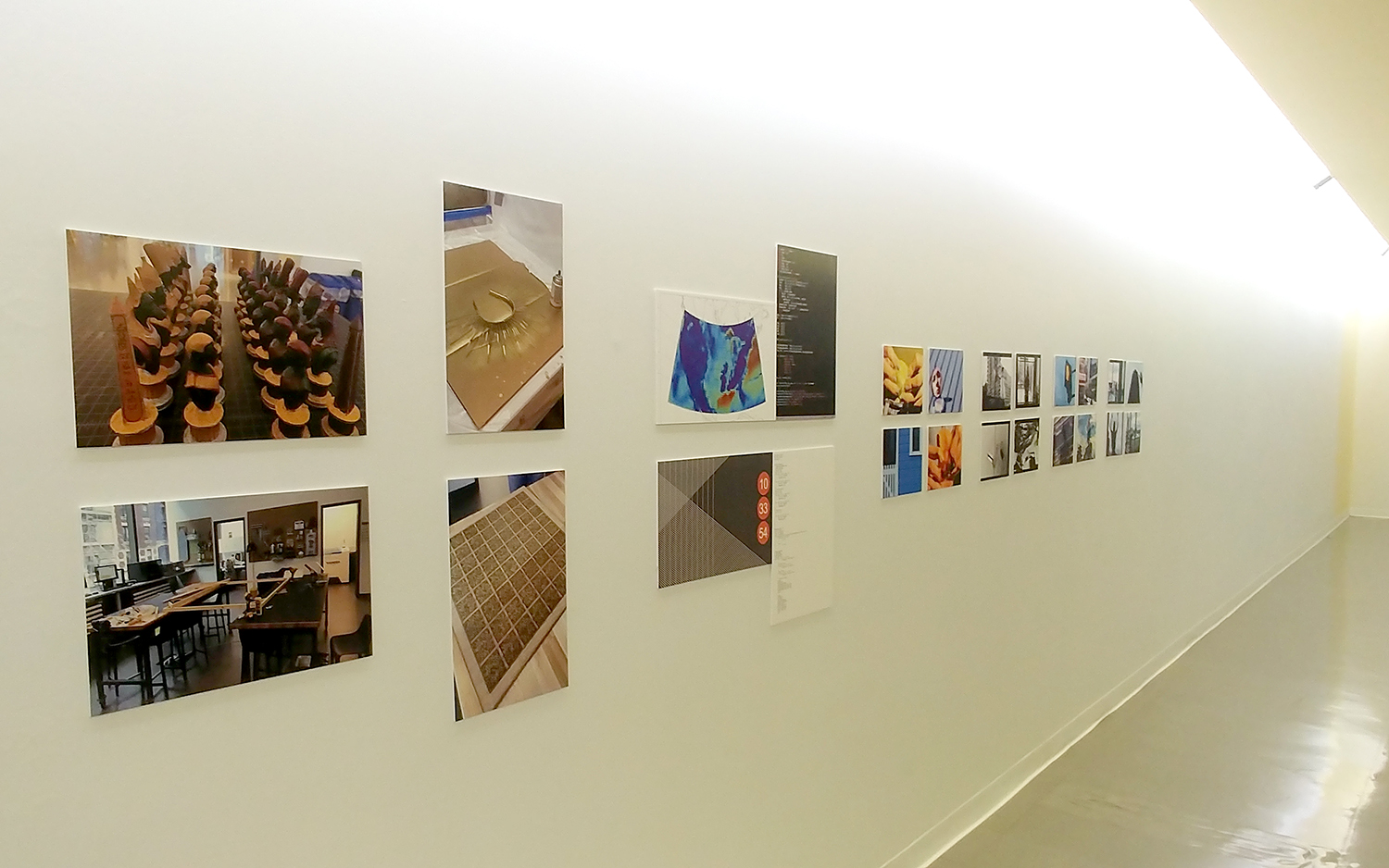 Photos of projects from the centers, hung on a long white wall.