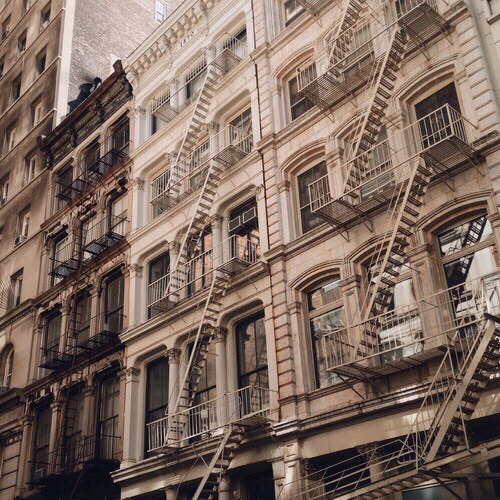 Facade of NYC tenement buildings, in muted colors